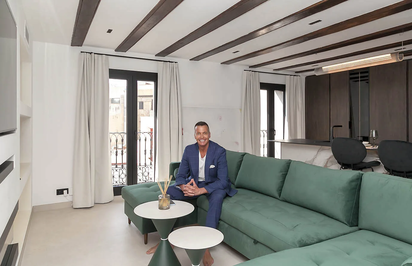 Angel Diez en un sofá de terciopelo verde en la residencia Santa Anna, Barcelona