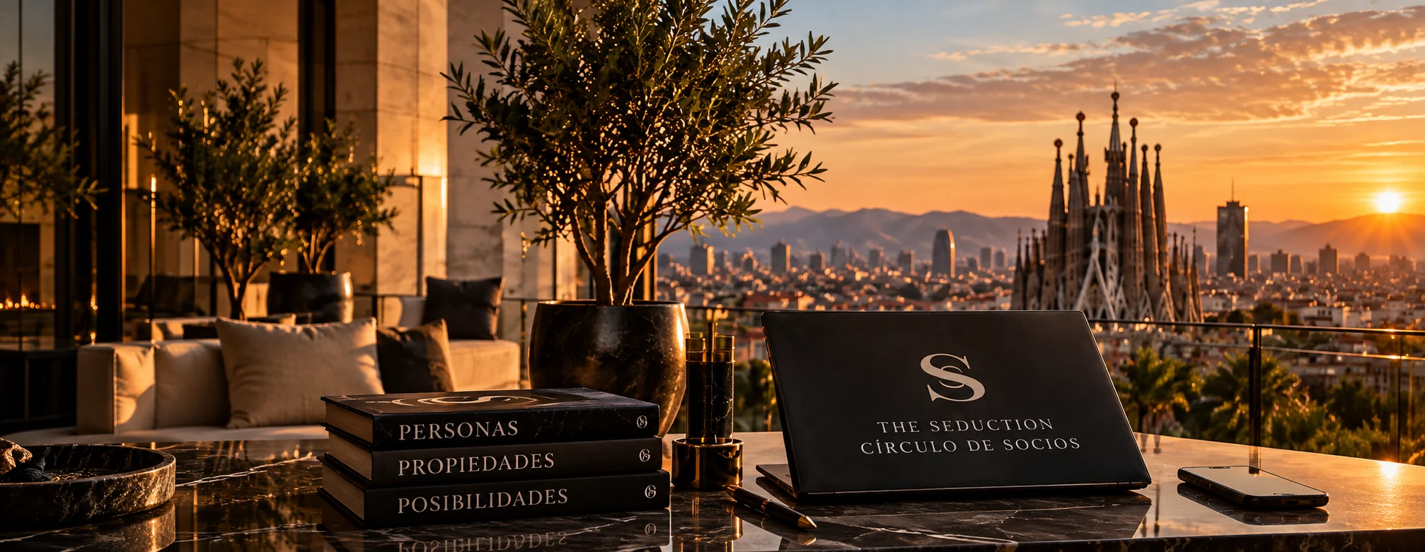 Mesa con la carpeta del Círculo de Socios de The Seduction y libros, con vistas a Barcelona y a la Sagrada Família