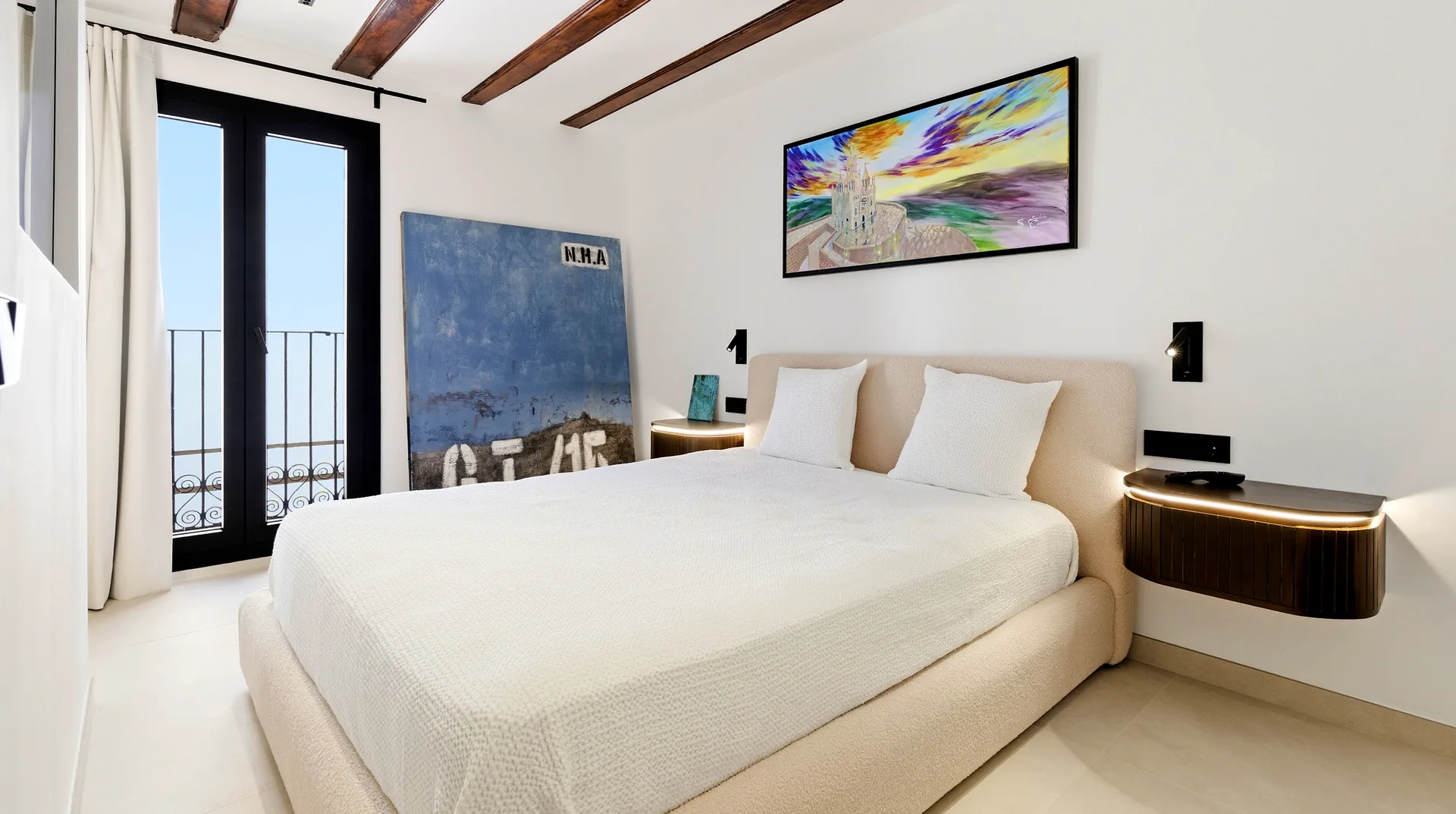Dormitorio con un cuadro de colores y balcón a la calle
